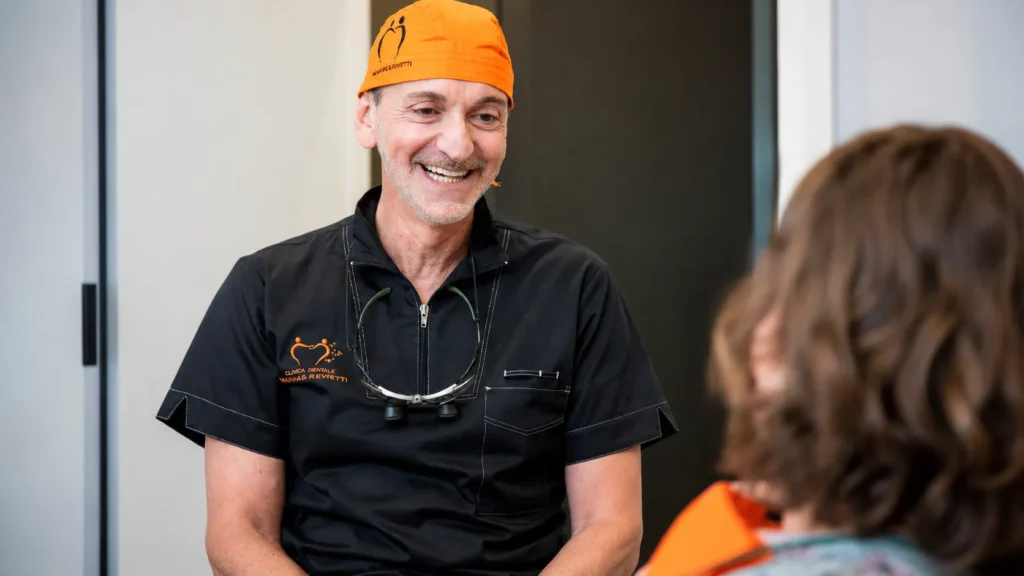 Il Dott. Alessandro Miggiano sorridente durante una consulenza con una paziente allo Studio Dentistico Miggiano Rivetti di Prato Sesia
