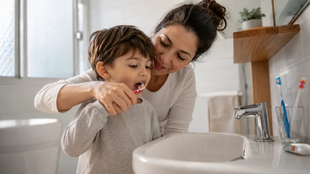 Madre insegna al figlio la corretta tecnica di spazzolamento per prevenire carie e ascesso dentale